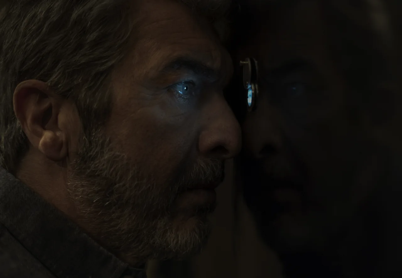 Primer plano de Ricardo Darín de perfil, con poca luz y un reflejo azulado en el ojo.