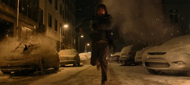 Bryan corre por una calle nocturna entre autos cubiertos de nieve y humo.