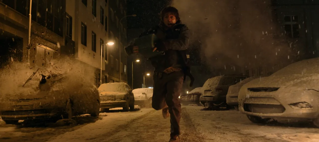 Bryan corre por una calle nocturna entre autos cubiertos de nieve y humo.